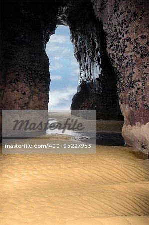 a view from the inside of a beach cave looking out at the sea