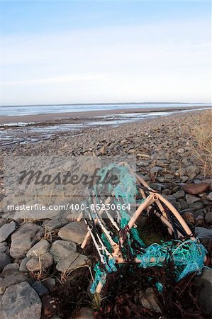 a lobster pot on a rocky irish beach on the west coast