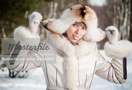 winter portrait of young and beautiful natural looking woman in casual clothes showing her tongue