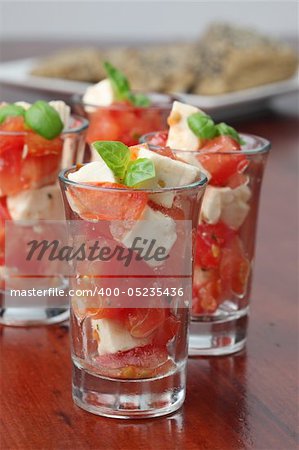 Appetizers with tomatoes, mozzarella and basil in small glasses