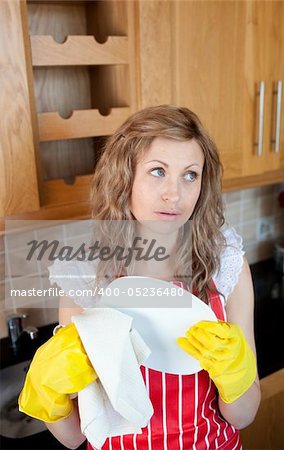 Attractive young woman drying dishes in the kitchen