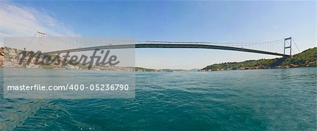 Ataturk suspension bridge spanning the Bosphorus river in Istanbul, Turkey against a blue sky