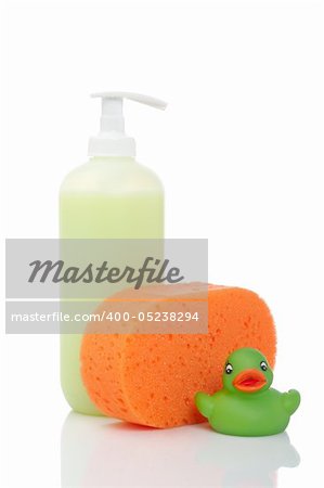 Rubber duck, plastic pump soap bottle and sponge reflected on white background