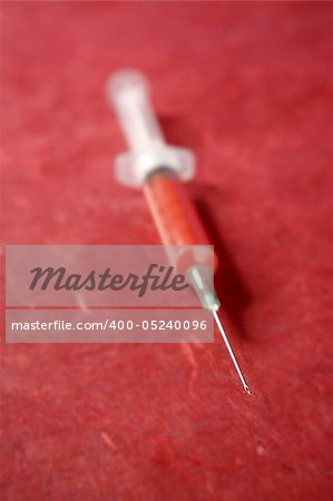 health red syringe vertical over red background