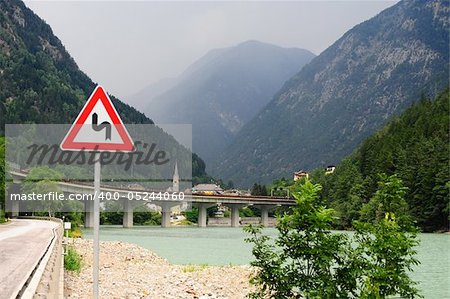 Dangerous Curves Sign At The Road Along Adige River in The Alps