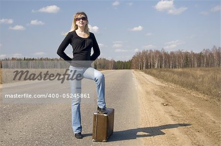 pretty girl waiting on the road with her baggage