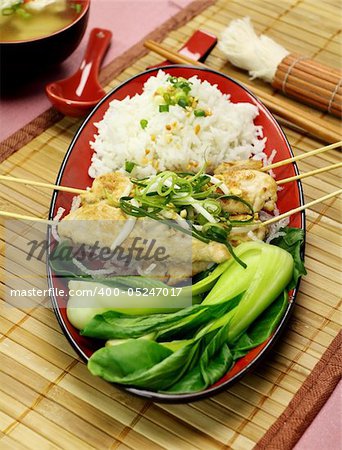 Asian chicken skewers with short soup and vegetables.