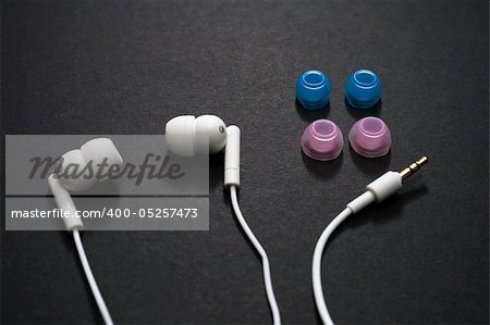 White earbuds and spare parts on a dark background