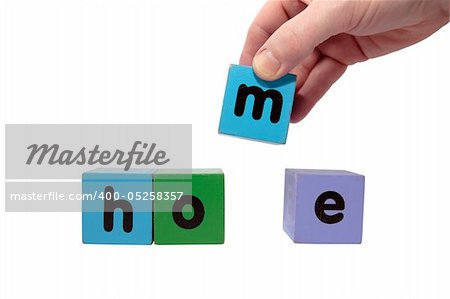 toy letters that spell home against a white background with clipping path with hand