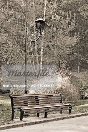 Old sepia photo of the bench in autumn park