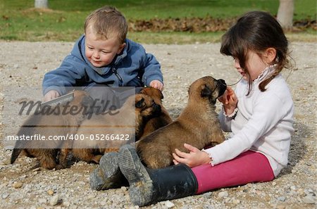 two children and very young puppies belgian shepherds