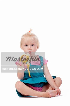 portrait of a little girl with blond hair eating banana - isolated on white