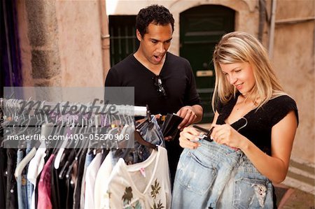 A couple shopping, looking at expensive clothes - shallow depth of field, focus on man