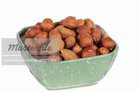 hazelnuts and almond in a cup isolated on white background
