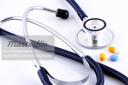 Tablets and a stethoscope on white background