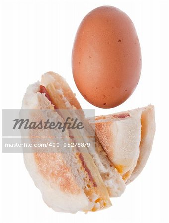 Sliced Bacon, Egg and Cheese Breakfast Sandwich with a Fresh Egg Isolated on White with a Clipping Path.