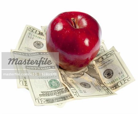 A red apple sits on top of a pile of $20 bills to illustrate the cost of education, food, or health care.  Studio shot on a white background.