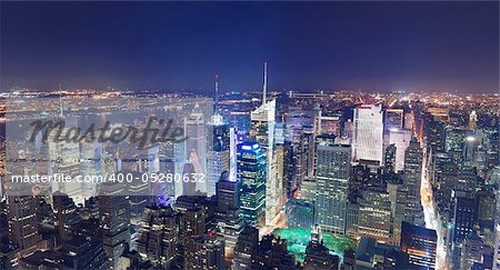 New York City Manhattan Times Square panorama aerial view at night with office building skyscrapers skyline illuminated by Hudson River.