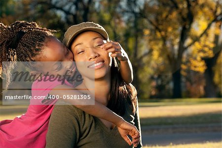 Happy African American mother and child having fun spending time together in a park