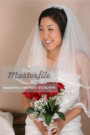 Beautiful bride wearing a traditional gown with red roses