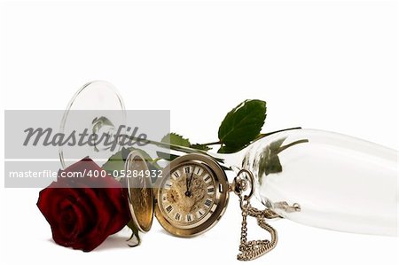 old pocket watch with a red wet rose under a lying champagne glass on white background