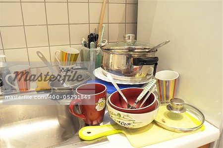 dirty dishes in a sink showing cleaning concept