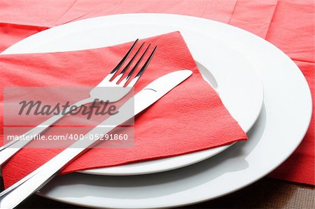 stainless fork knife and plate set on a table