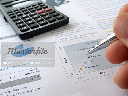 Male hand with pen on the investment chart with calculator