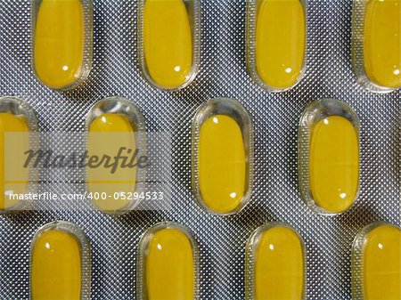 Yellow pills in blister background