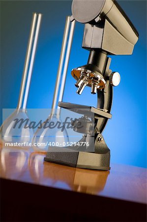 Microscope against blue gradient background