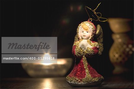 Red and golden christmas angel with candles in the night