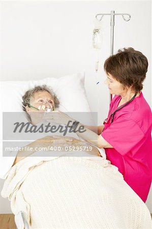 Senior woman in the hospital with lung disease, getting oxygen from a nurse.