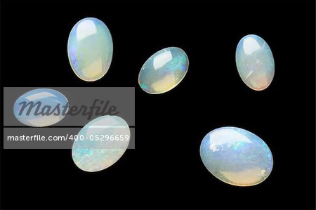 Few white opals isolated on black.