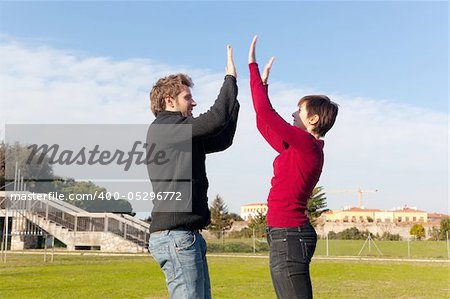 Young Man with Woman Jumping and Giving High Five