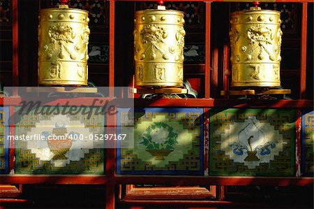 Three golden prayer wheels in the sunlight,Tibet
