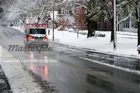 An ambulance driving to an emergency on a snow day