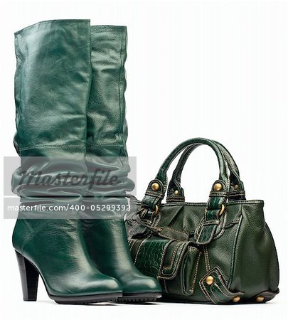 Green female high-heeled boots and leather bag on white background