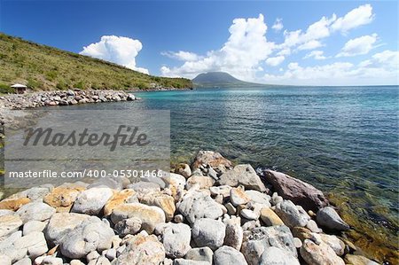 The rocky coastline on the island of Saint Kitts with Nevis in the backdrop.