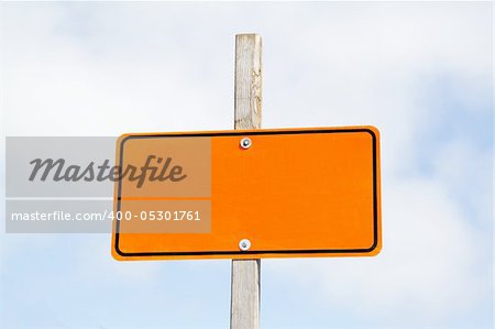 Bright orange road sign over cloudy sky