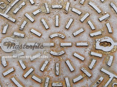 The image of a manhole cover connotes a variety of ideas, including that which is underground, smelly, sewage and subterranean.