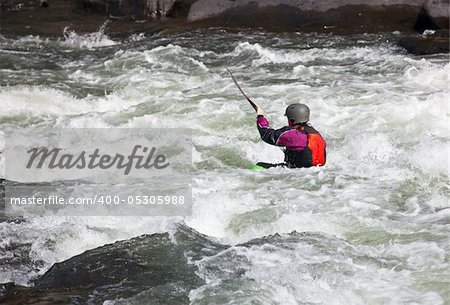 Canoeing in white water in rapids on river with the kayak starting to sink in the waves