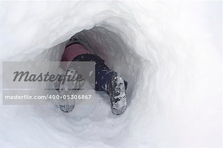 Child playing in snow tunnel