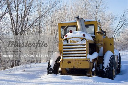 Snow covered tractor abandoned