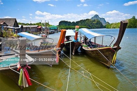 colorful longboats at a pier in the Phang Nga Bay