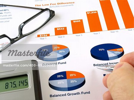 Male hand with pen on the investment chart with calculator and glasses