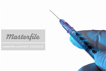 Hand in a glove holding a medical syringe on a white background.