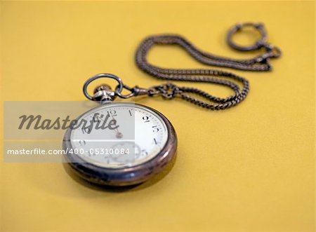 Close up of vintage pocket watch over golden background