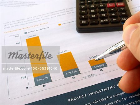Male hand with pen on the project investment chart with calculator