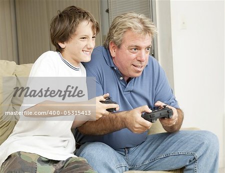 Father or uncle playing video games with a little boy - his son or nephew.