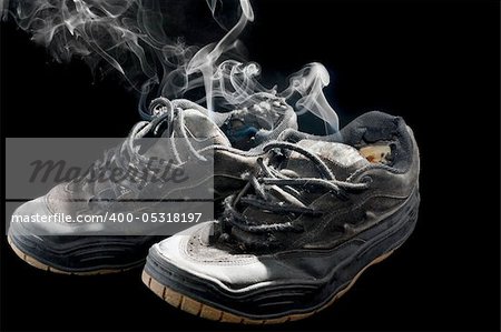 pair of smelly old sneakers on a black background